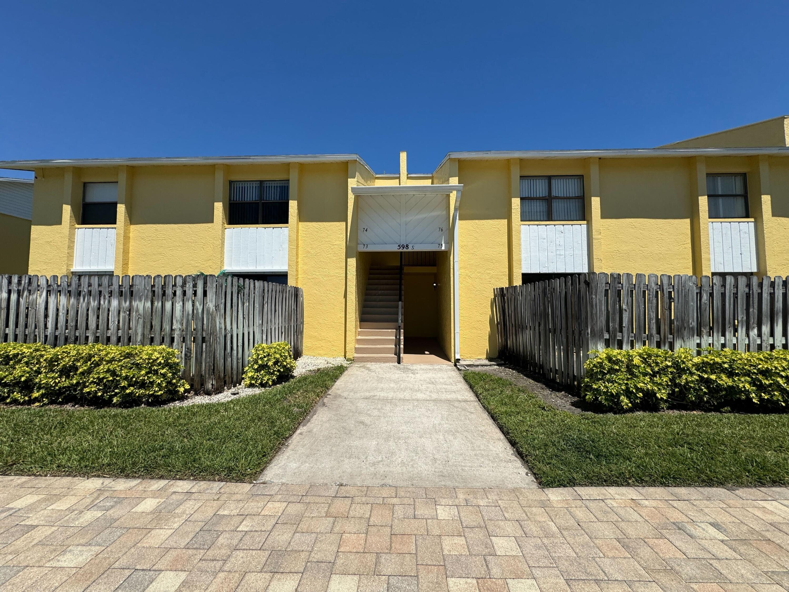 598 North Wickham Road, Unit 75 Melbourne, FL 32935 - Photo 1 of 21 a front view of a house with a yard