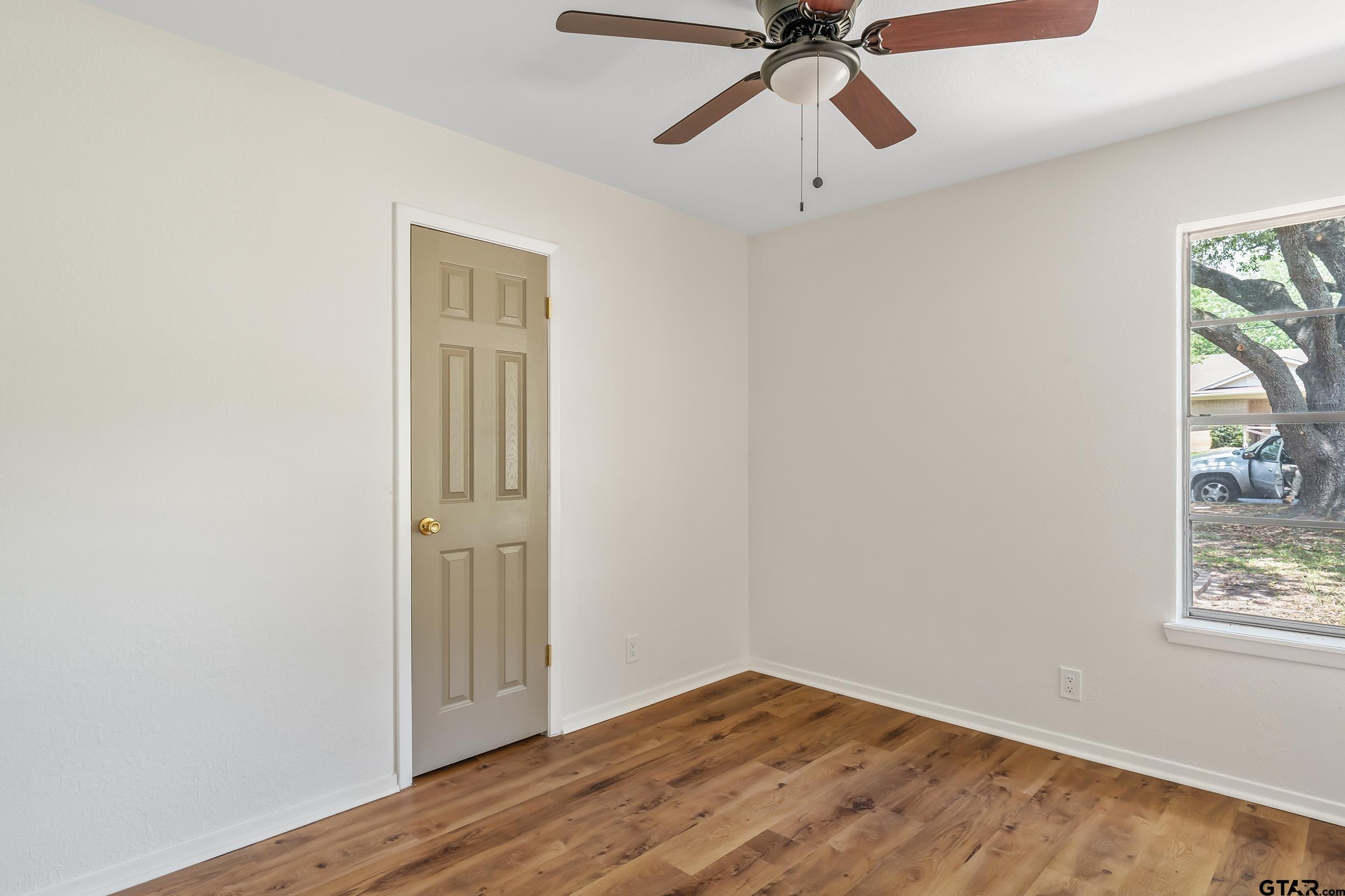 1602 Bowie Circle Tyler, TX 75701 - Photo 4 of 9 a view of empty room with wooden floor and fan