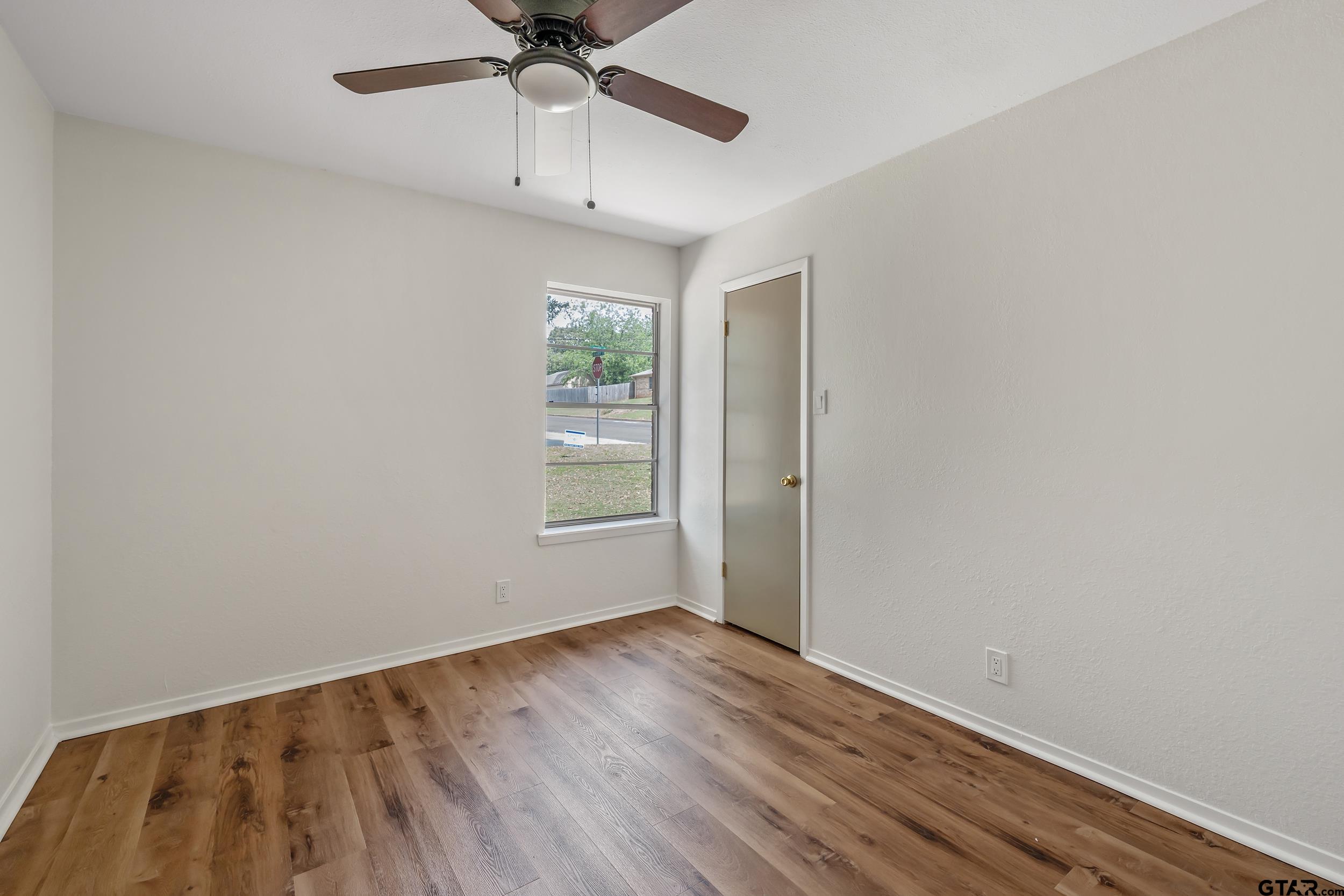 1602 Bowie Circle Tyler, TX 75701 - Photo 5 of 9 wooden floor in an empty room with a window