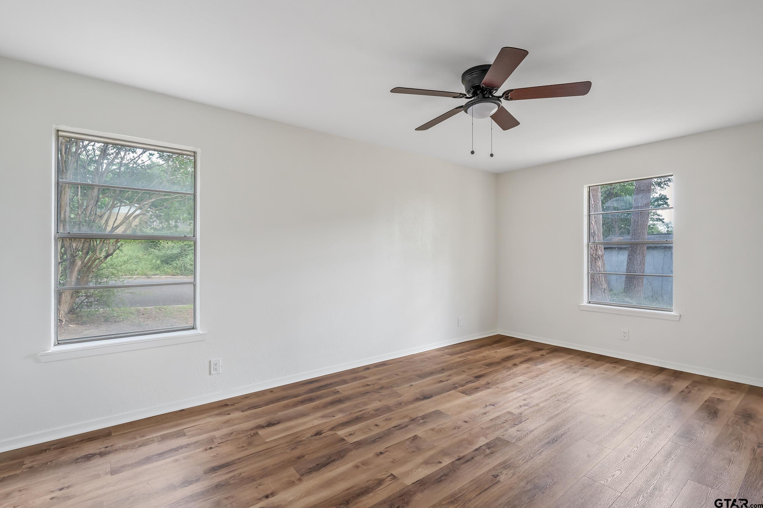 1602 Bowie Circle Tyler, TX 75701 - Photo 7 of 9 a view of an empty room with wooden floor and a window
