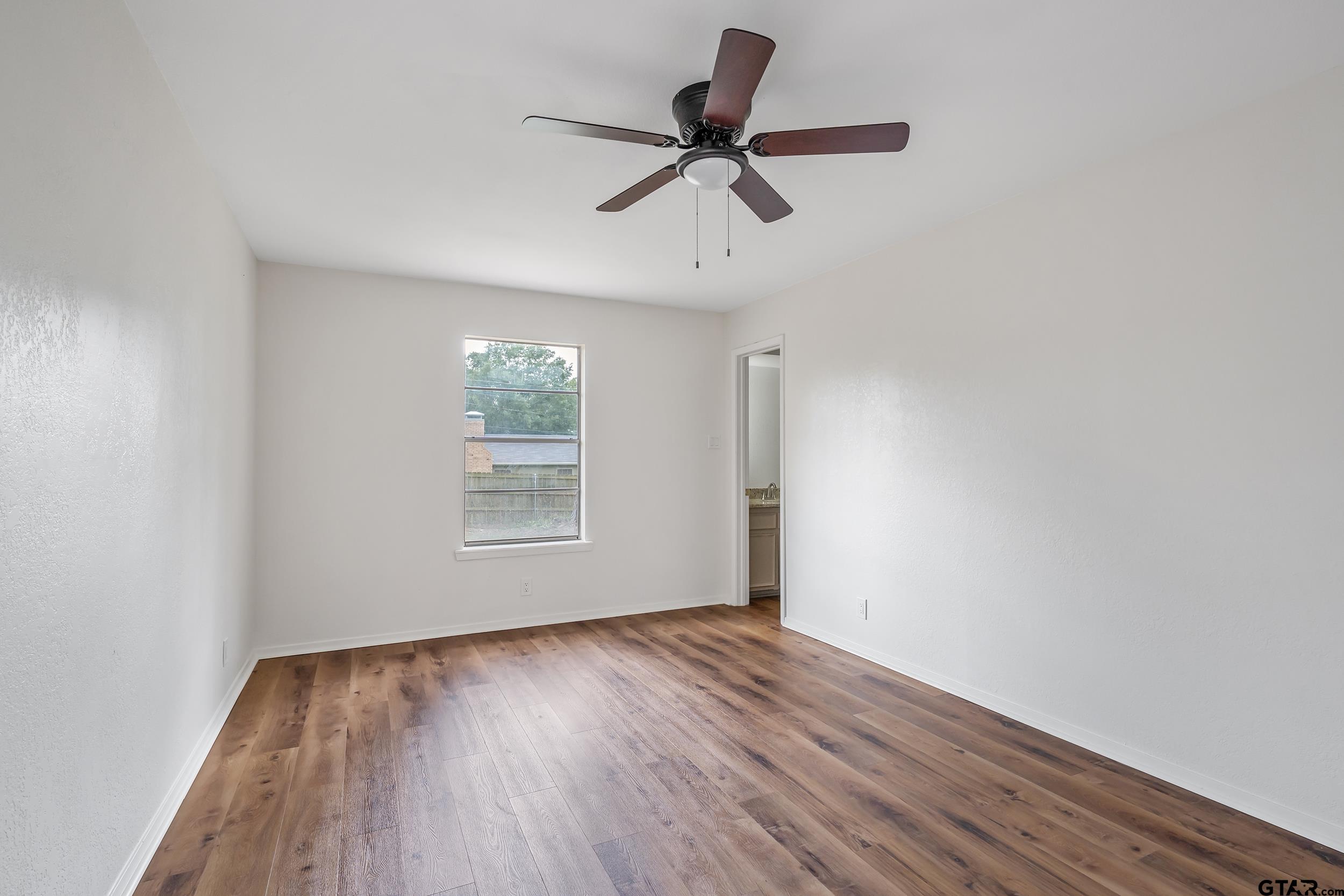 1602 Bowie Circle Tyler, TX 75701 - Photo 8 of 9 a view of empty room with wooden floor and fan