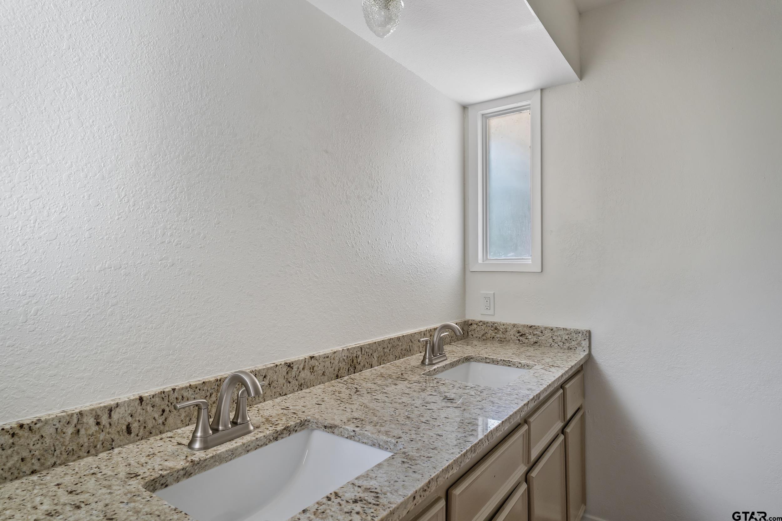 1602 Bowie Circle Tyler, TX 75701 - Photo 9 of 9 a bathroom with a granite countertop sink and a mirror
