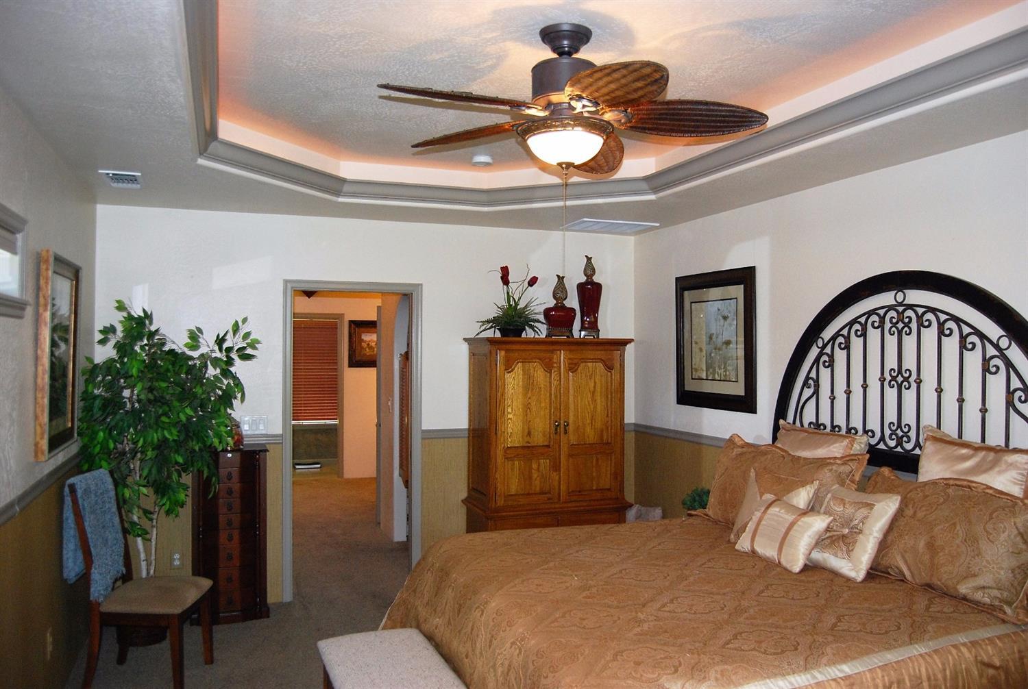1136 Grouse Ridge Drive Central Point, OR 97502 - Photo 15 of 35 a bedroom with a bed a chandelier and potted plant on the dresser