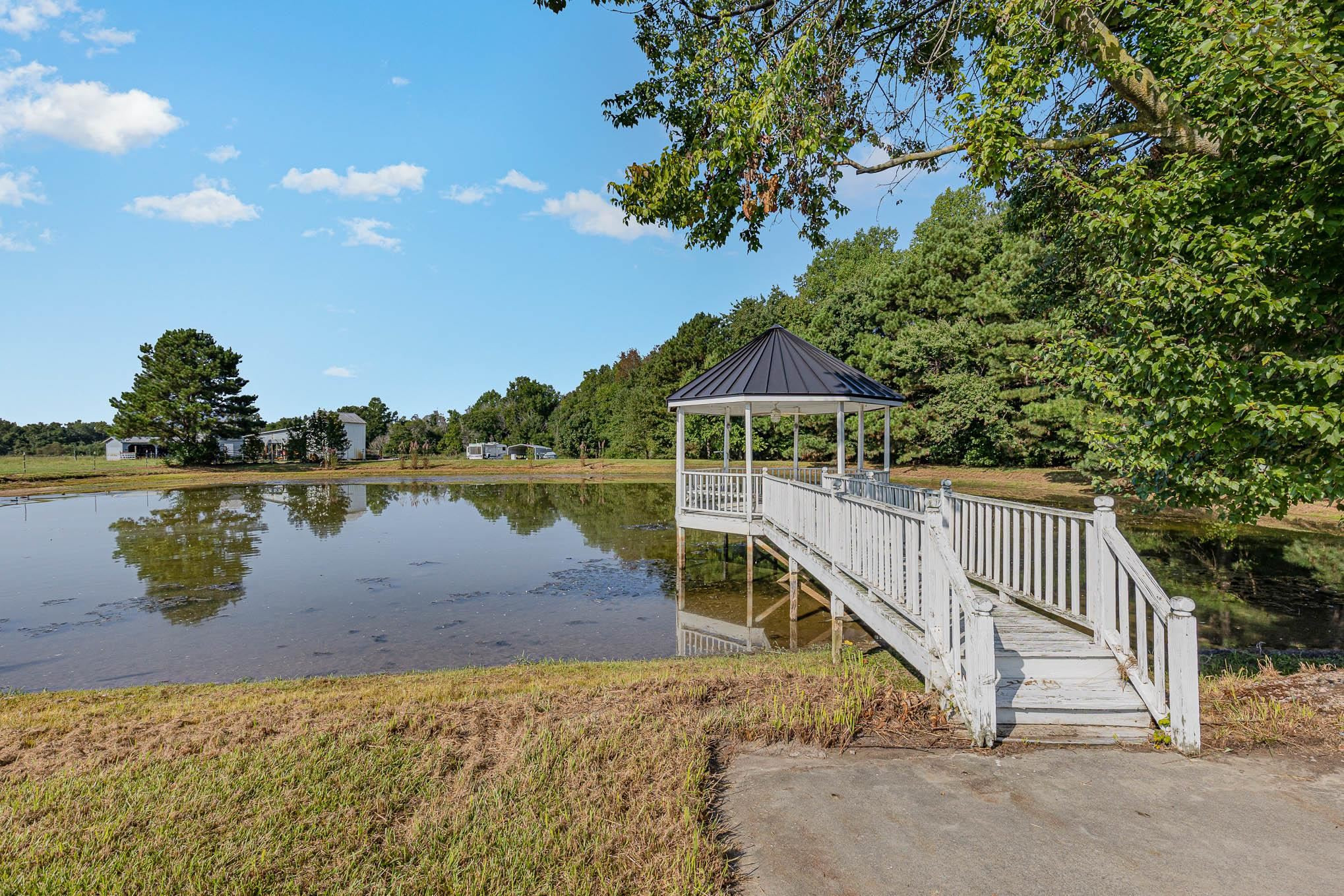 3591 Zacks Mill Road Angier, NC 27501 - Photo 36 of 44 a view of a lake with a floor to ceiling window and wooden fence