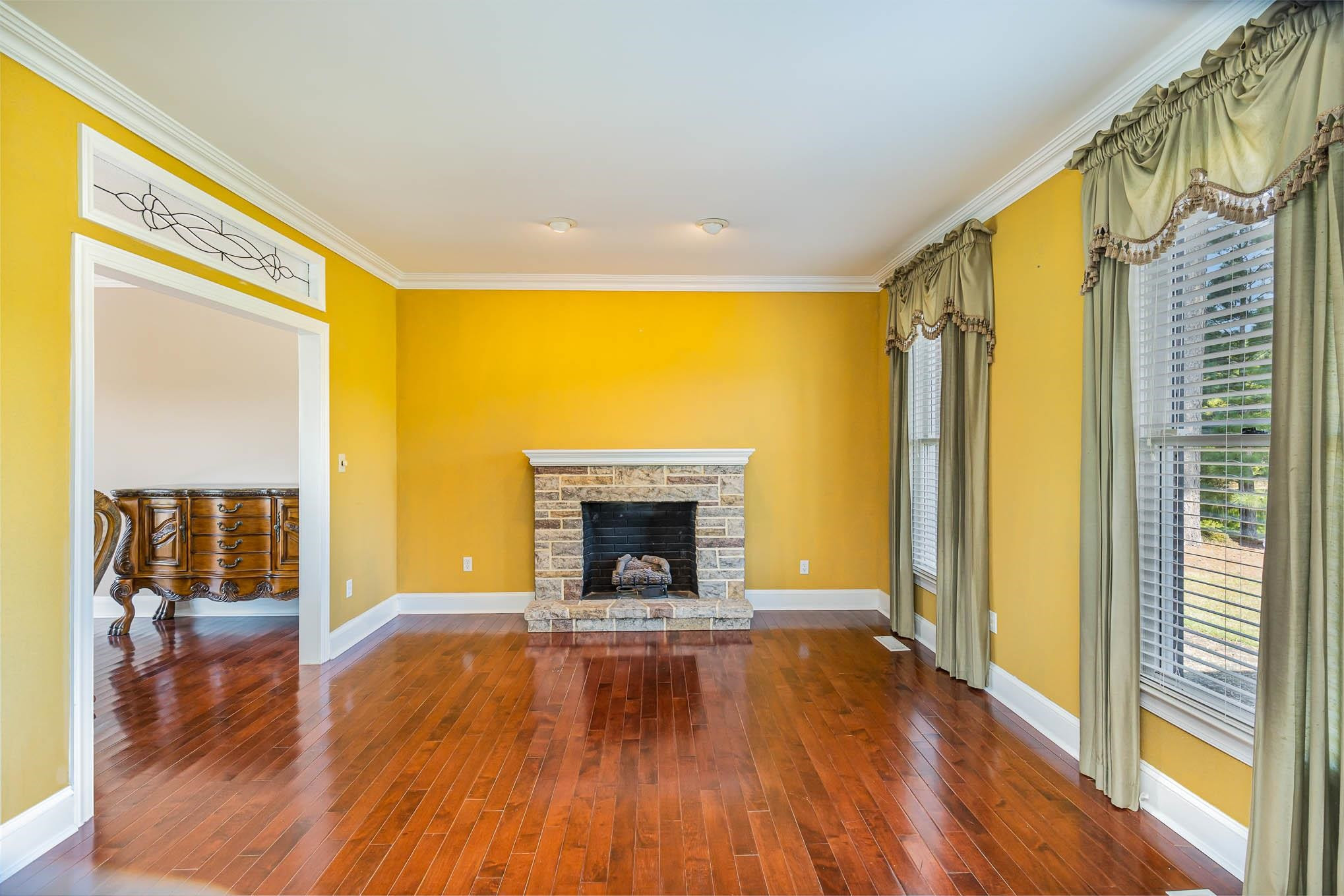 3591 Zacks Mill Road Angier, NC 27501 - Photo 44 of 44 a view of an empty room with wooden floor fireplace and a window
