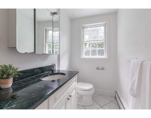 25 Twitchell Street Wellesley, MA 02482 - Photo 9 of 23 a bathroom with a granite countertop sink a large mirror a toilet and a window