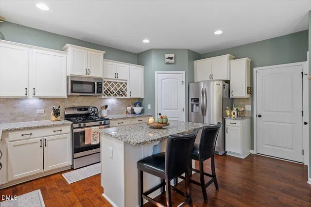 a kitchen with stainless steel appliances granite countertop a stove refrigerator sink and cabinets