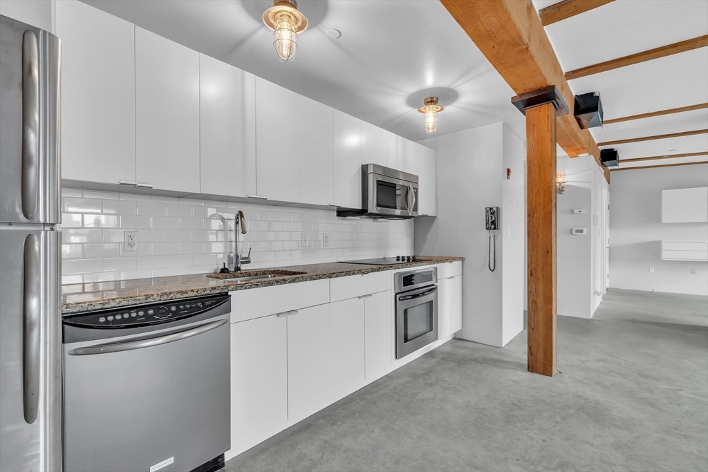 90 Wareham Street, Unit 505 Boston, MA 02118 - Photo 7 of 11 a kitchen with stainless steel appliances granite countertop a stove a sink and a refrigerator