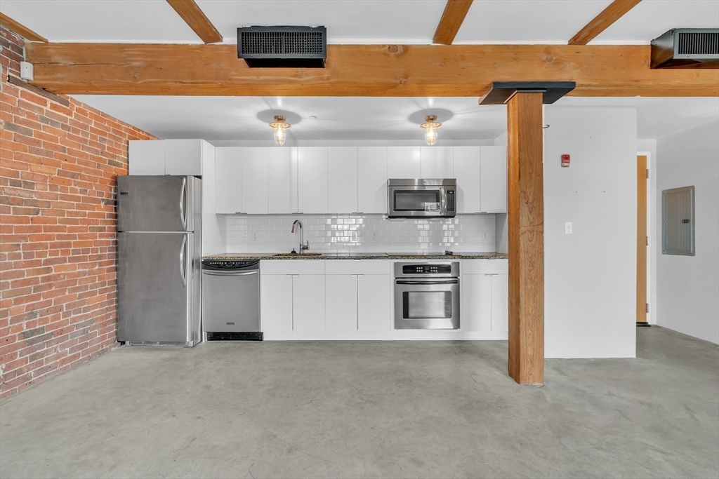 90 Wareham Street, Unit 505 Boston, MA 02118 - Photo 8 of 11 a kitchen with stainless steel appliances granite countertop a refrigerator and a stove