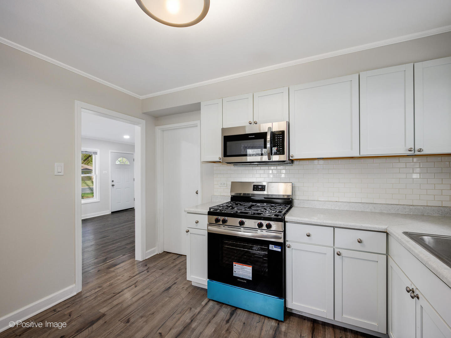 353 Blackhawk Drive Park Forest, IL 60466 - Photo 9 of 15 a kitchen with stainless steel appliances a stove a sink cabinets and a wooden floor