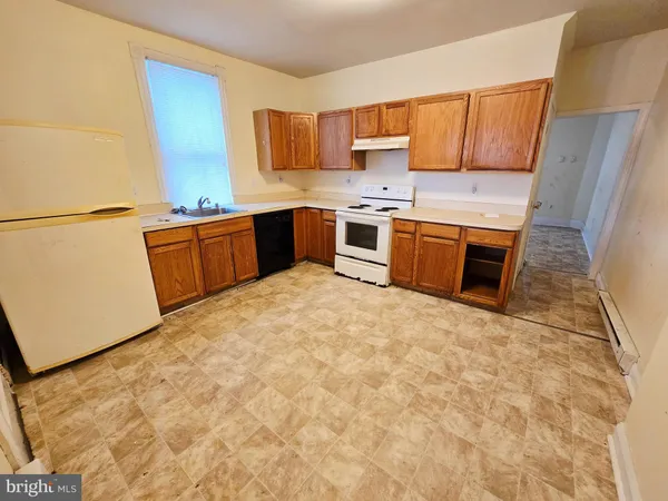 a kitchen with stainless steel appliances a stove a sink a refrigerator a counter top space and cabinets