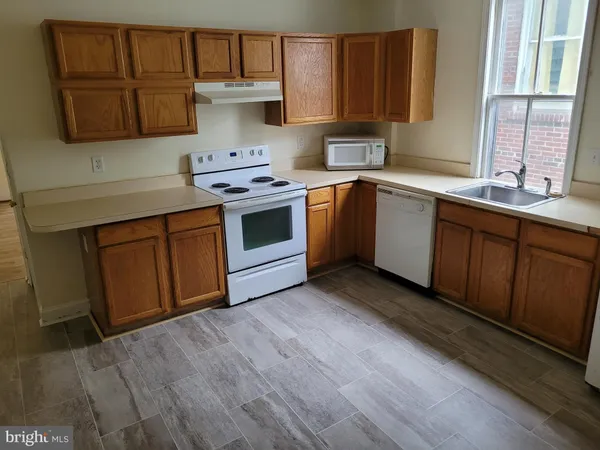 a kitchen with a sink cabinets and a window