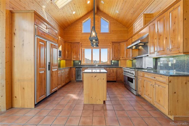 a kitchen with stainless steel appliances granite countertop a stove a sink and a refrigerator