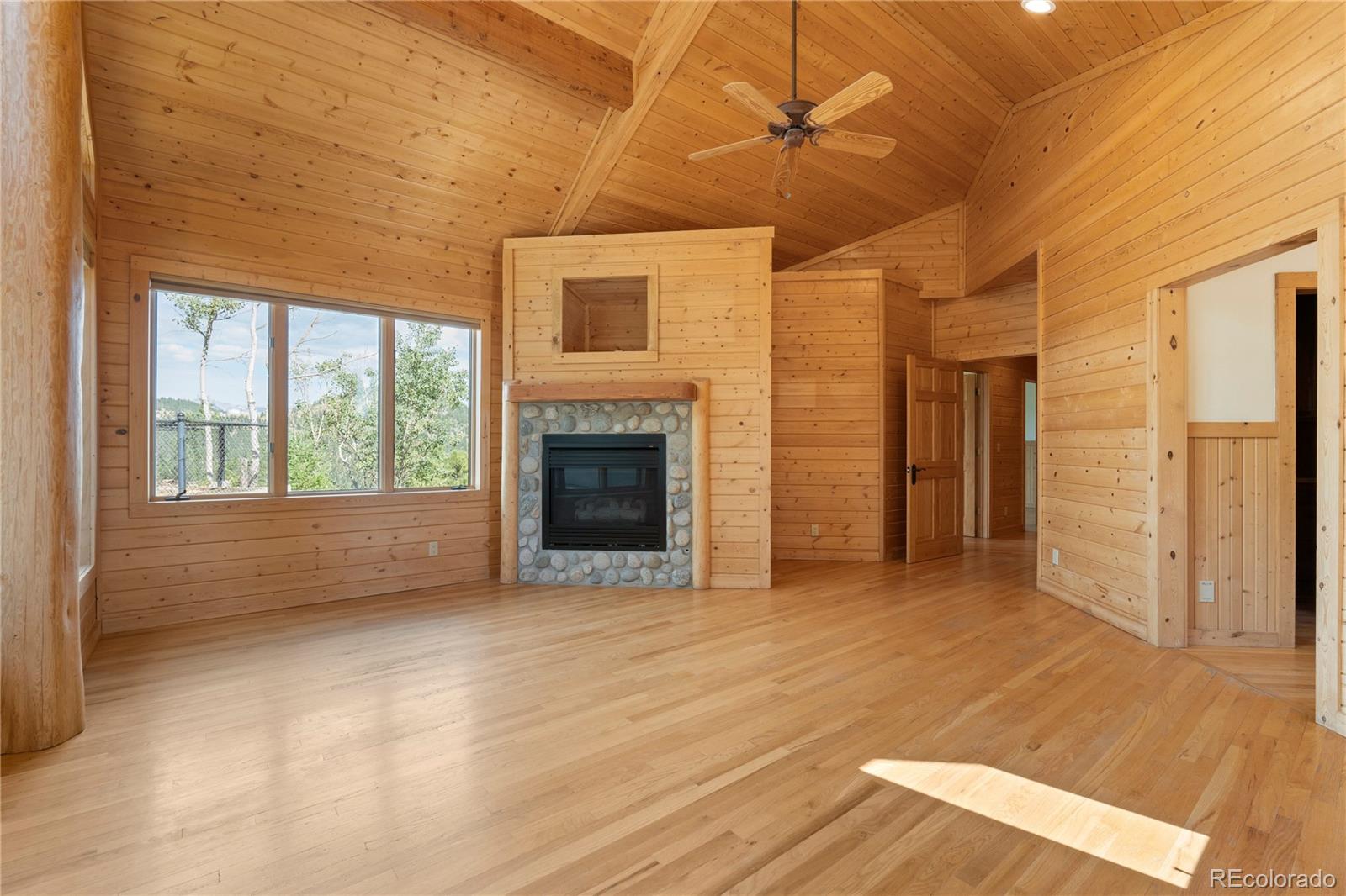 2489 Gross Dam Road Golden, CO 80403 - Photo 26 of 47 a view of empty room with wooden floor and fireplace