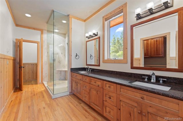 a bathroom with double vanity and a mirror