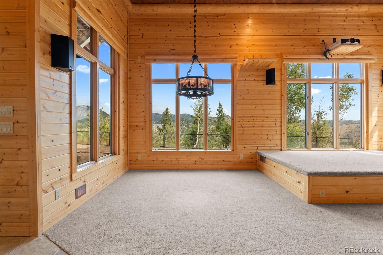 2489 Gross Dam Road Golden, CO 80403 - Photo 34 of 47 a spacious bedroom with a large window and a chandelier