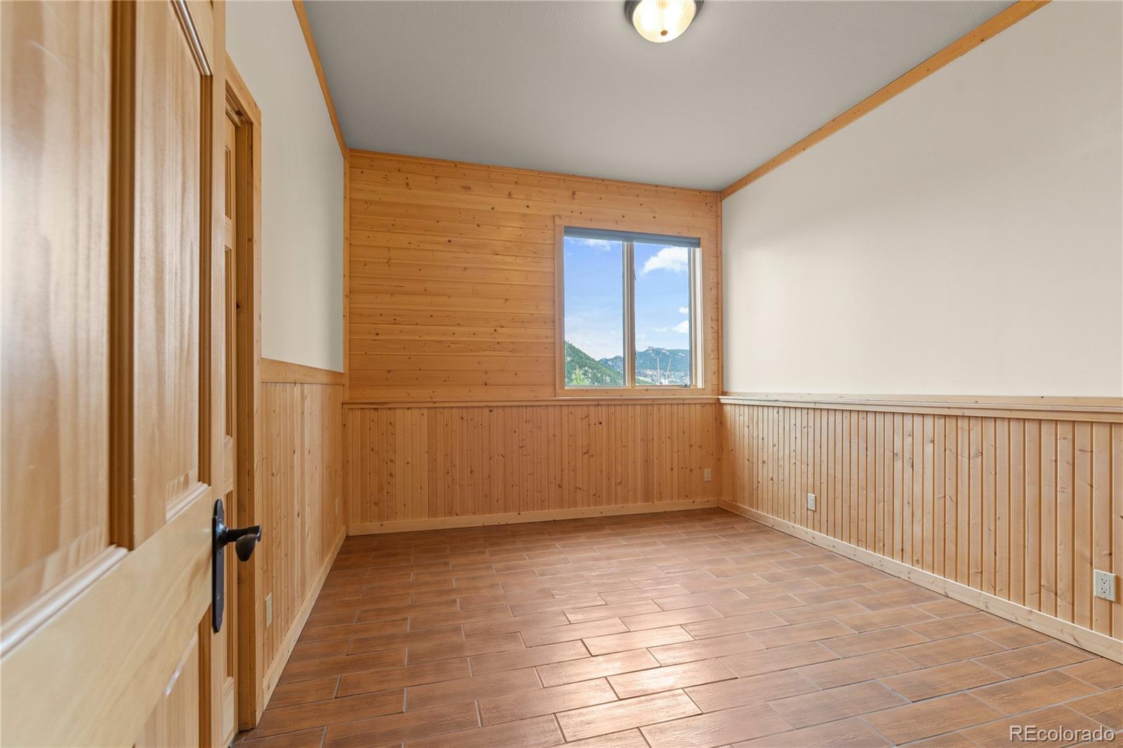2489 Gross Dam Road Golden, CO 80403 - Photo 37 of 47 a view of an empty room with wooden floor and a window