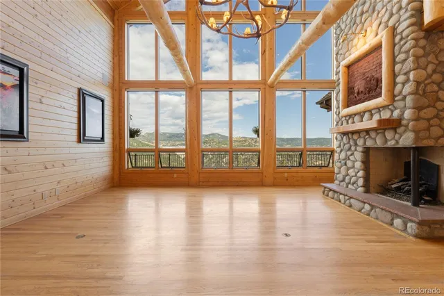 a view of an empty room with wooden floor and a fireplace