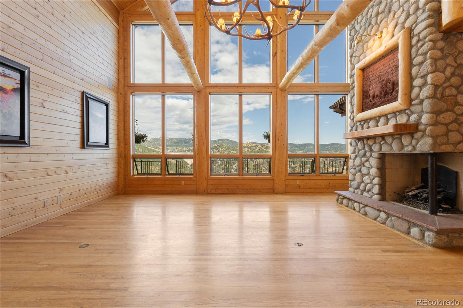 2489 Gross Dam Road Golden, CO 80403 - Photo 10 of 47 a view of an empty room with wooden floor and a fireplace