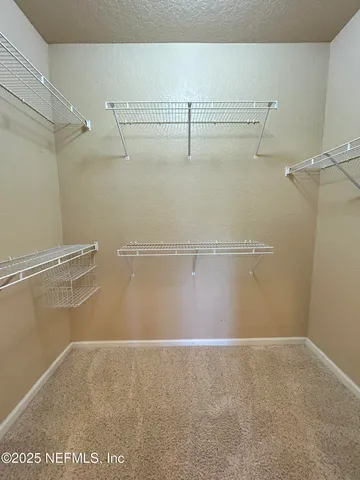 en empty room with windows and chandelier fan