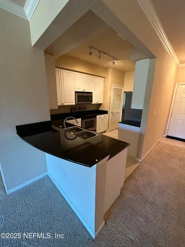 a kitchen with a sink and refrigerator