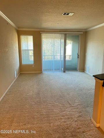 an empty room with windows and ceiling fan
