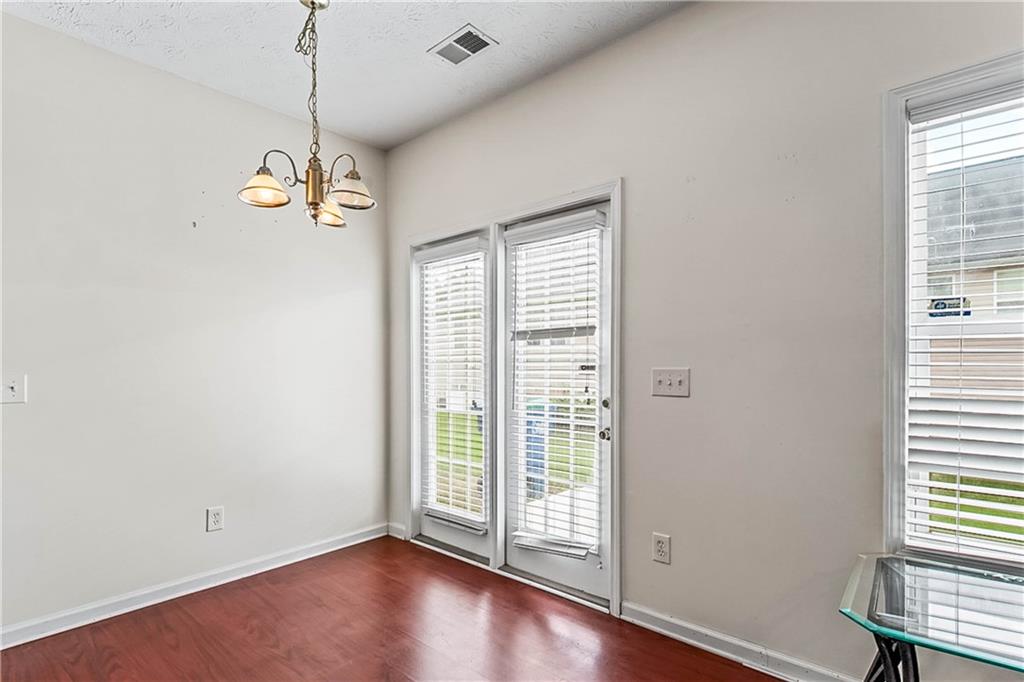 2555 Flat Shoals Road, Unit 2006 Atlanta, GA 30349 - Photo 14 of 29 an empty room with wooden floor windows and a ceiling fan