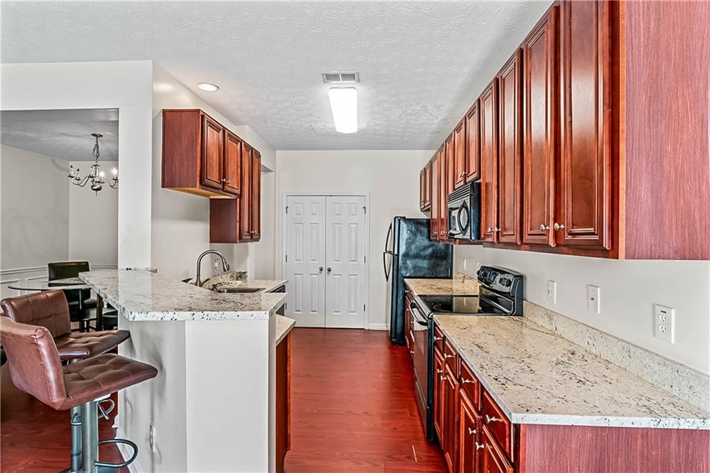 2555 Flat Shoals Road, Unit 2006 Atlanta, GA 30349 - Photo 17 of 29 a kitchen that has a sink a stove and a wooden cabinets