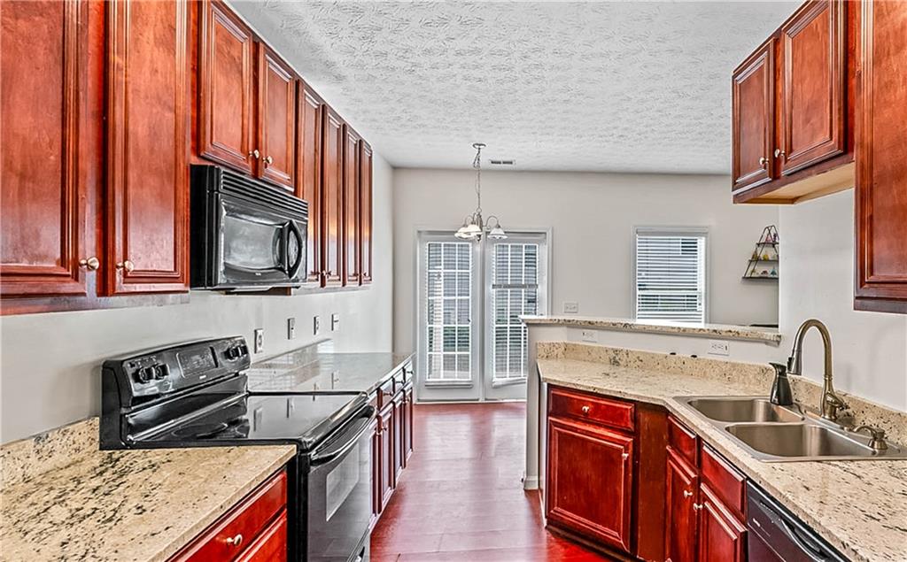 2555 Flat Shoals Road, Unit 2006 Atlanta, GA 30349 - Photo 18 of 29 a kitchen with stainless steel appliances granite countertop a sink stove and cabinets