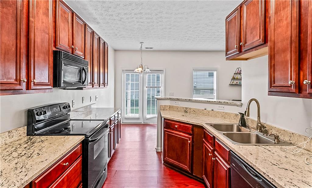 2555 Flat Shoals Road, Unit 2006 Atlanta, GA 30349 - Photo 19 of 29 a kitchen with stainless steel appliances granite countertop a sink stove and cabinets