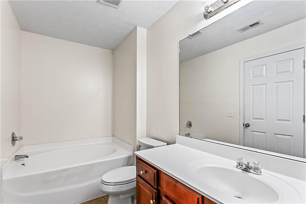 2555 Flat Shoals Road, Unit 2006 Atlanta, GA 30349 - Photo 25 of 29 a bathroom with a sink a toilet and shower