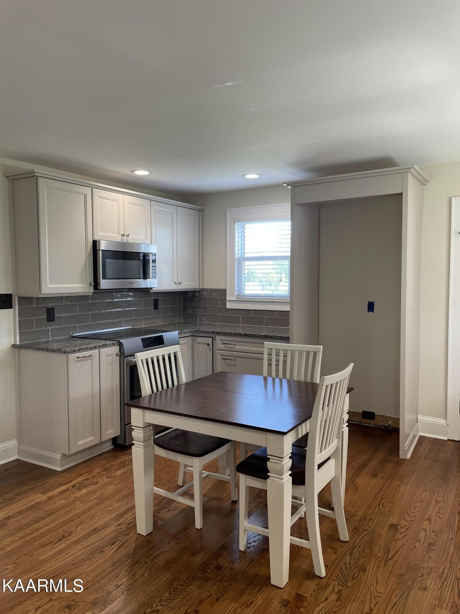 7522 Clapps Chapel Road Corryton, TN 37721 - Photo 6 of 12 a kitchen with granite countertop a dining table chairs and wooden floor