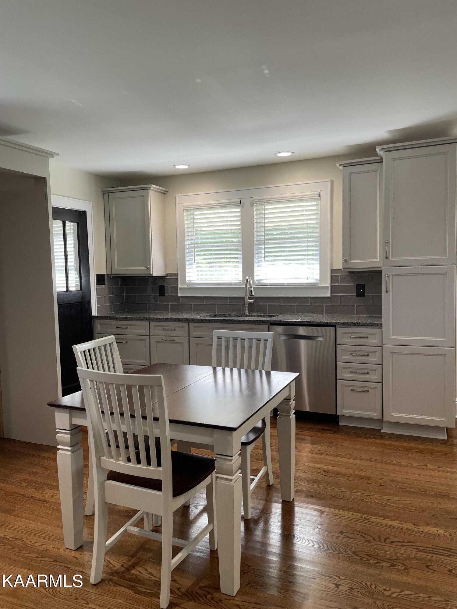 7522 Clapps Chapel Road Corryton, TN 37721 - Photo 8 of 12 a kitchen with granite countertop a dining table chairs cabinets wooden floor and appliances