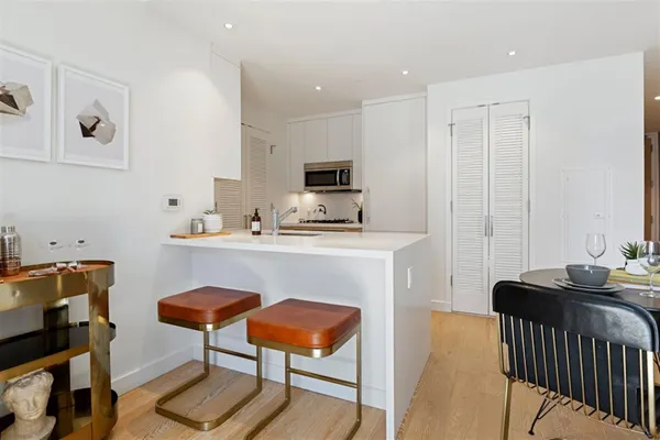 a kitchen with a table chairs refrigerator and a sink