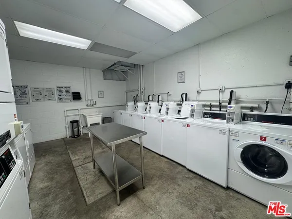 a kitchen with a sink a stove and white cabinets