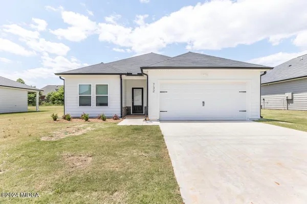 a view of a house with backyard and a garage