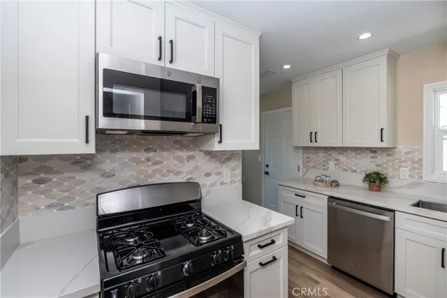 a kitchen with stainless steel appliances a sink a stove and microwave