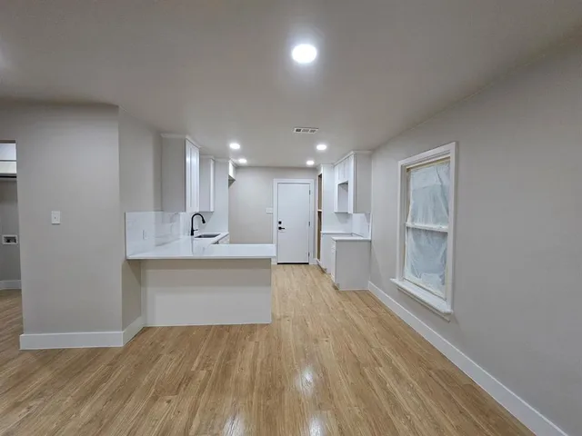 a view of large kitchen with wooden floor and kitchen