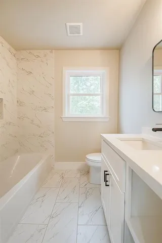 a spacious bathroom with a bathtub sink and toilet