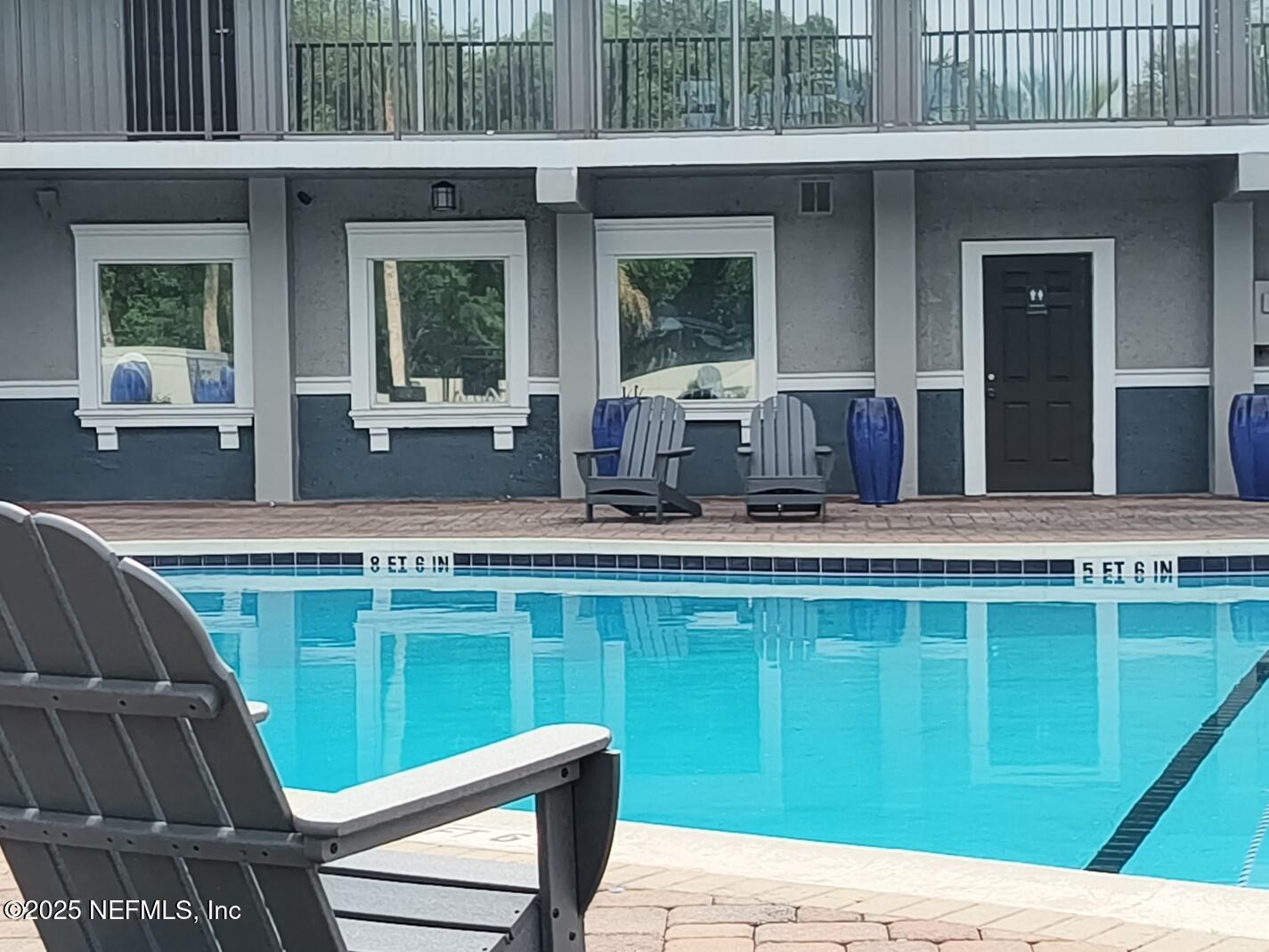 a view of pool with two chairs and a table