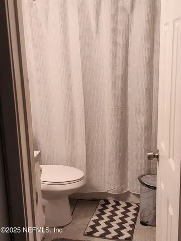 a bathroom with a toilet and a shower curtain