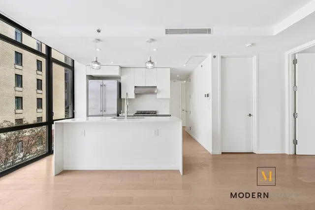 a white kitchen with stainless steel appliances granite countertop a refrigerator a sink and a stove