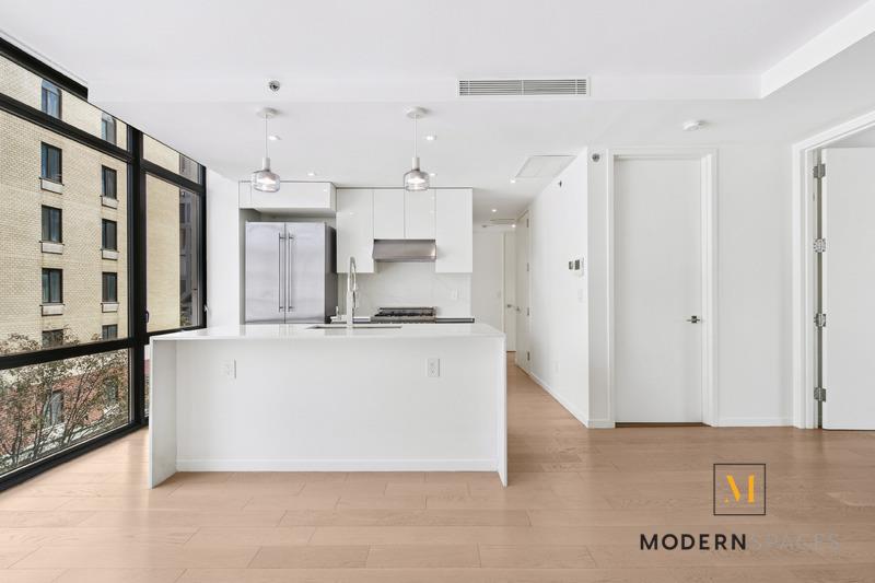 24-12 42nd Road, Unit 4A Queens, NY 11101 - Photo 5 of 17 a white kitchen with stainless steel appliances granite countertop a refrigerator a sink and a stove