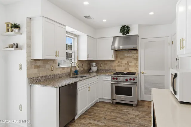a kitchen with stainless steel appliances granite countertop a stove a sink and a refrigerator