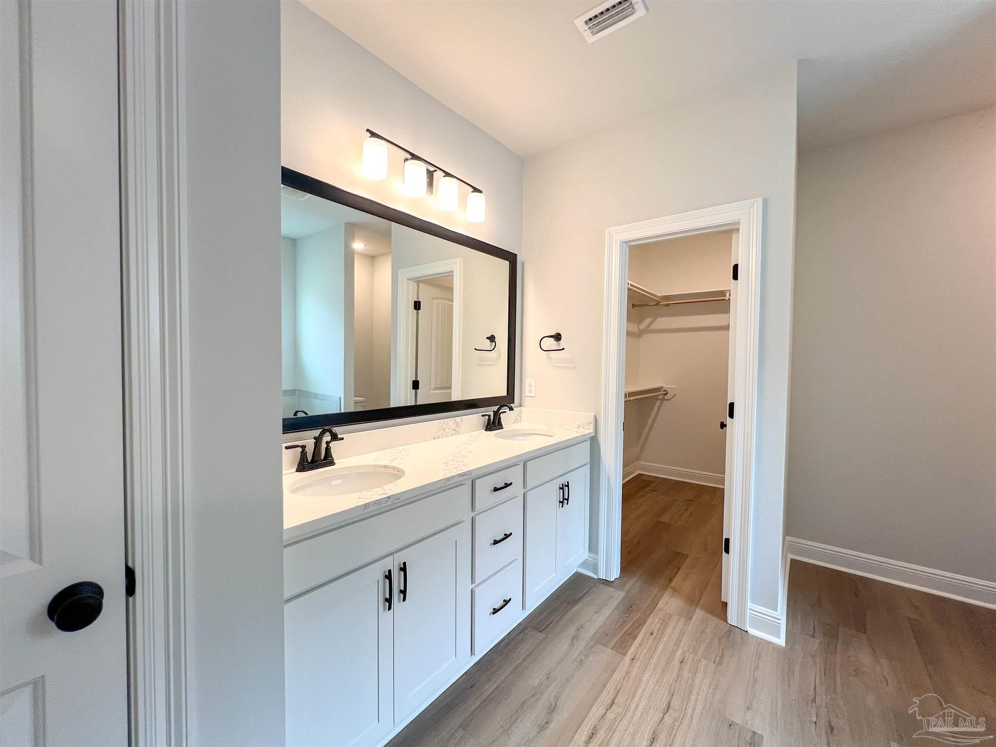 4605 Sago Palm Circle Milton, FL 32571 - Photo 17 of 33 a spacious bathroom with a double vanity sink a mirror and shower
