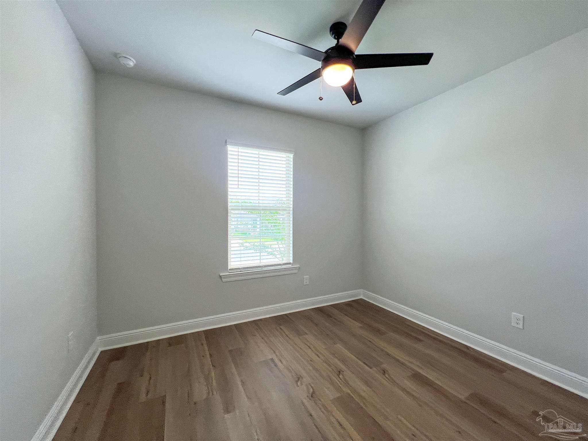 4605 Sago Palm Circle Milton, FL 32571 - Photo 24 of 33 an empty room with wooden floor and windows