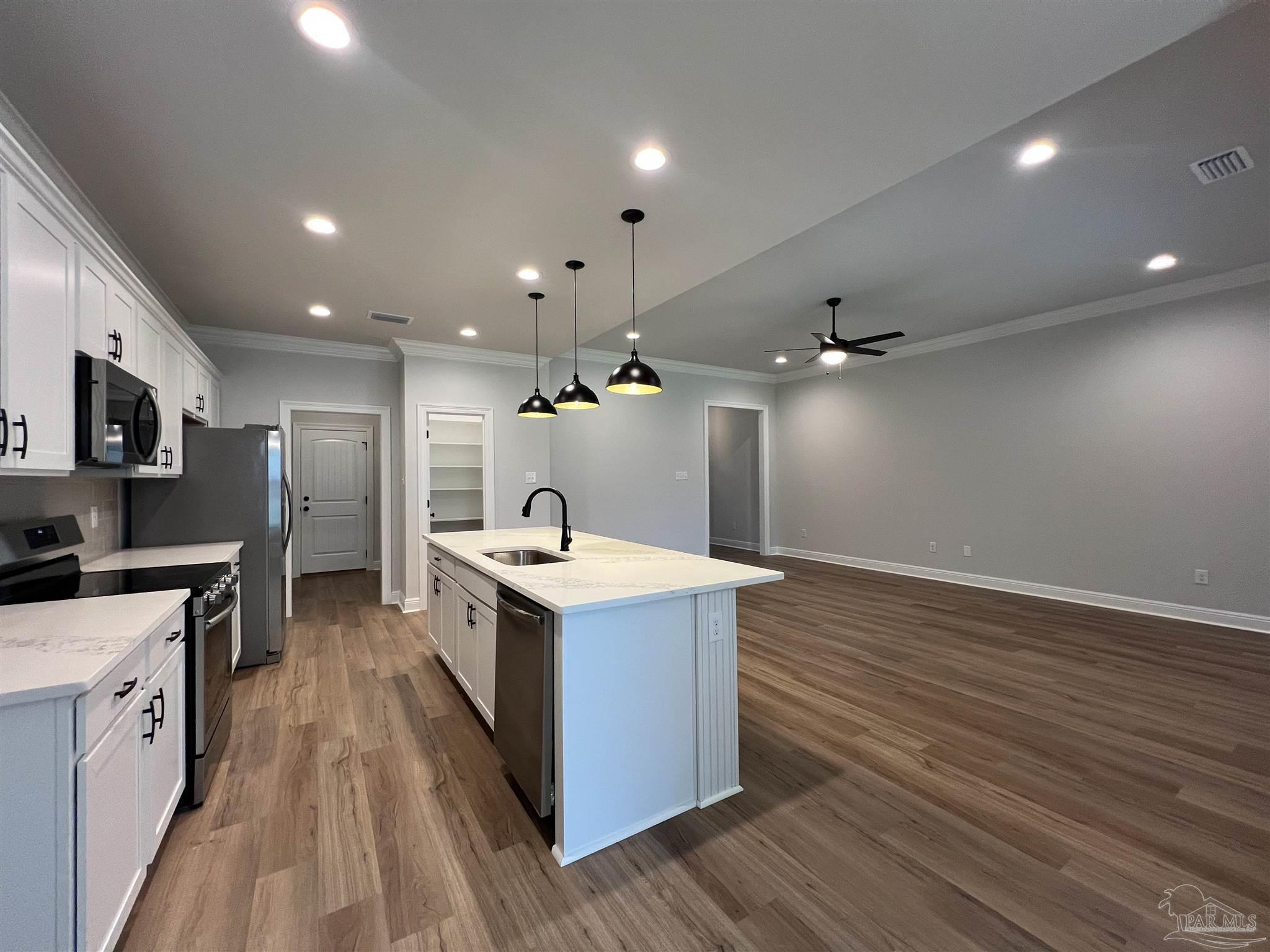 4605 Sago Palm Circle Milton, FL 32571 - Photo 5 of 33 a kitchen with a stove a sink and a refrigerator