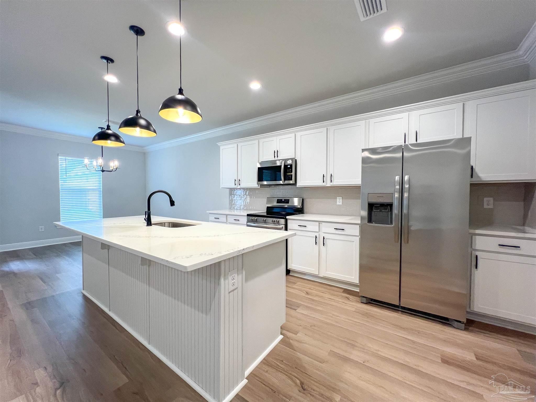 4605 Sago Palm Circle Milton, FL 32571 - Photo 6 of 33 a kitchen with a sink a counter top space stainless steel appliances and cabinets