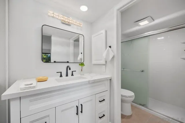 a bathroom with a toilet sink double vanity and mirror