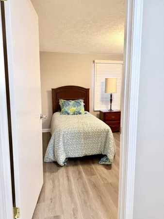 a bedroom with a bed dresser and a window